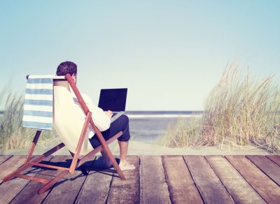 man on beach with laptop