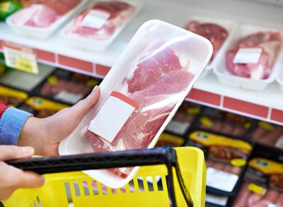 hand buying meat without back at grocery store