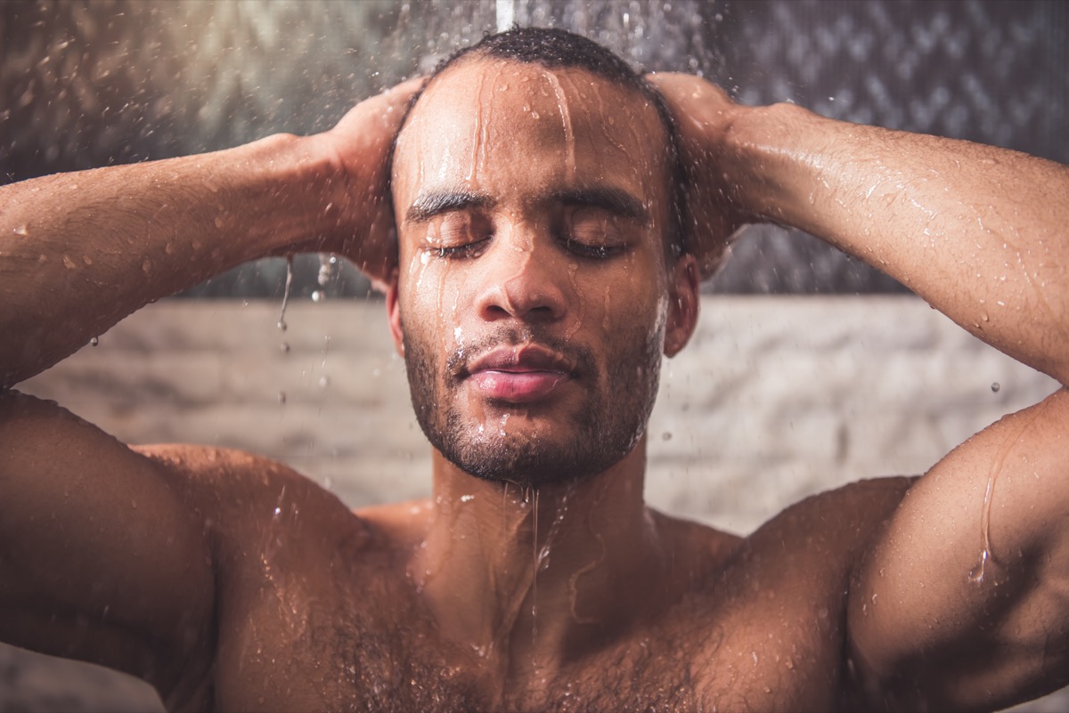 man is taking shower in bathroom