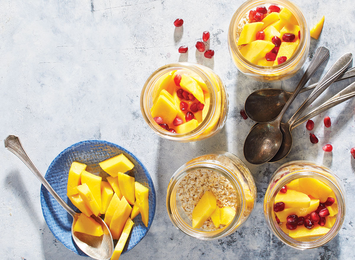 tarros de avena para la noche con mango y jengibre con cucharas y semillas de granada