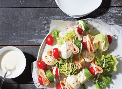 chefs salad eggs on sticks with yogurt on white plate and gray background