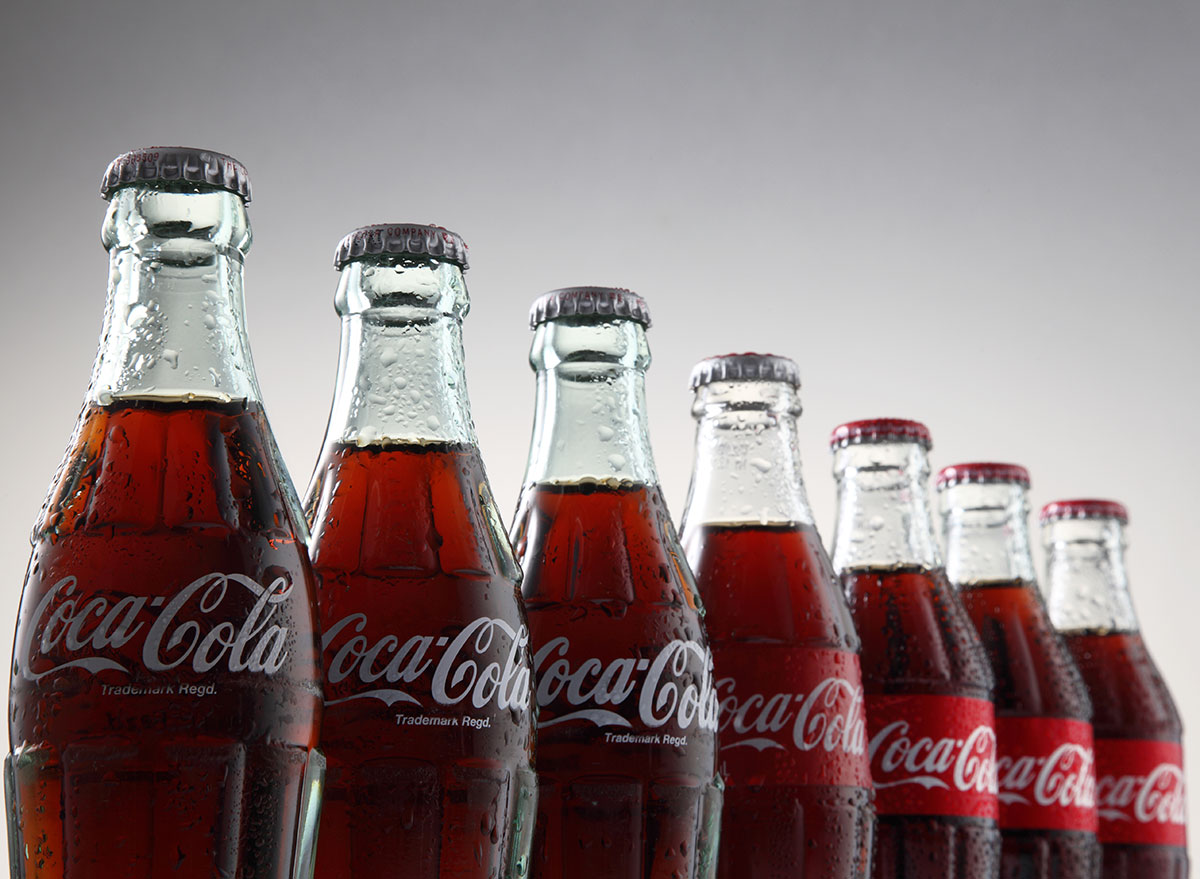https://www.eatthis.com/wp-content/uploads/sites/4/2019/07/glass-coke-bottles-in-line.jpg