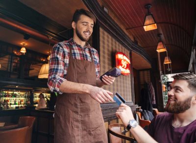 Waiter taking card as customer pays the bill.