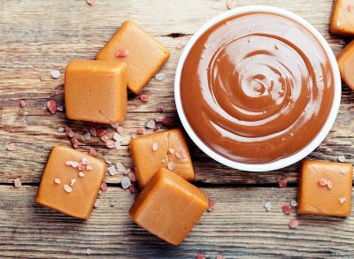 caramel squares next to a bowl of melted caramel