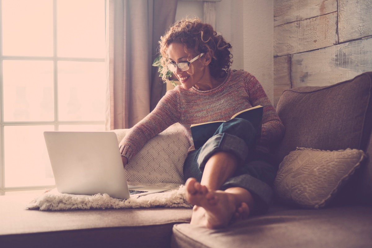 middle age woman working at home sit on the sofa using a laptop