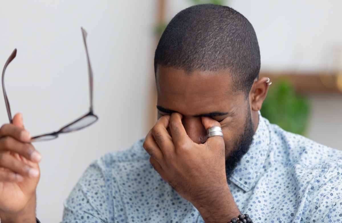 businessman taking off glasses rubbing dry irritated eyes