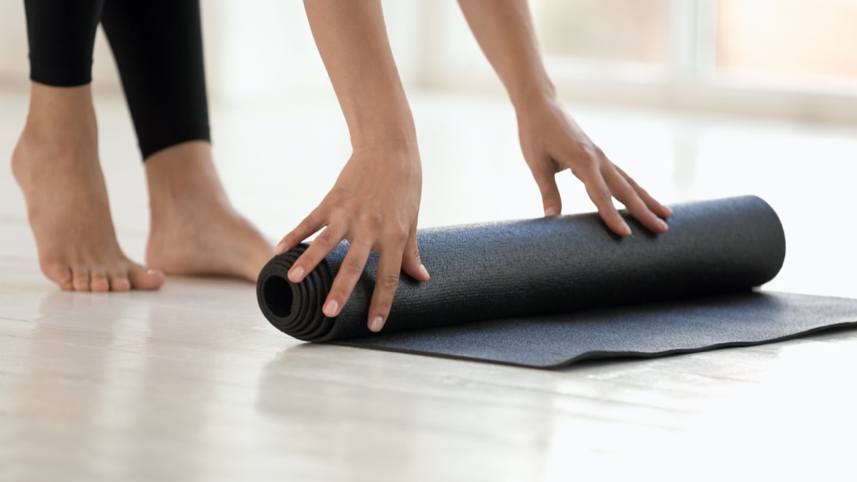 Mujer con leggings negros terminados o comenzando el entrenamiento, alfombra rodante