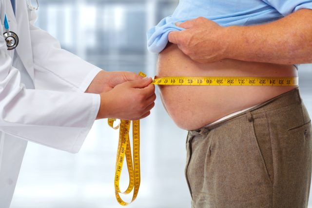 A doctor who measures body fat in the lower back of obese men.Obesity and weight loss