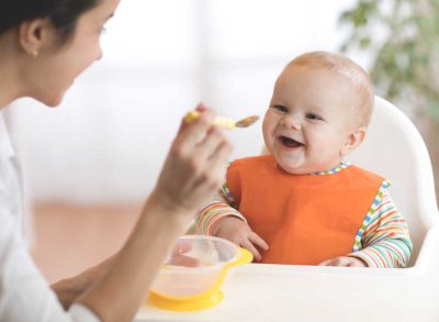 Mother feeding child baby food