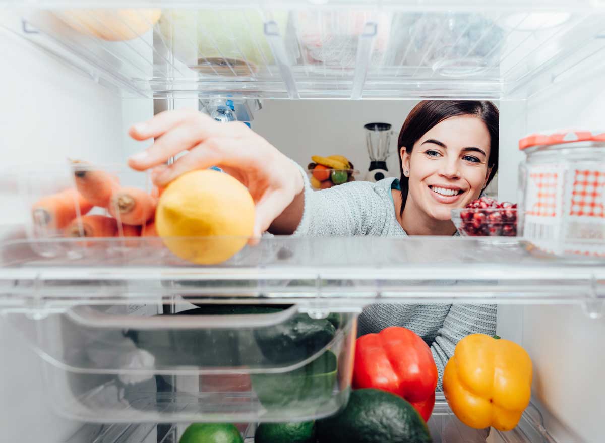https://www.eatthis.com/wp-content/uploads/sites/4/2019/12/woman-reaching-into-fridge-healthy-food-lemon.jpg?quality=82&strip=1