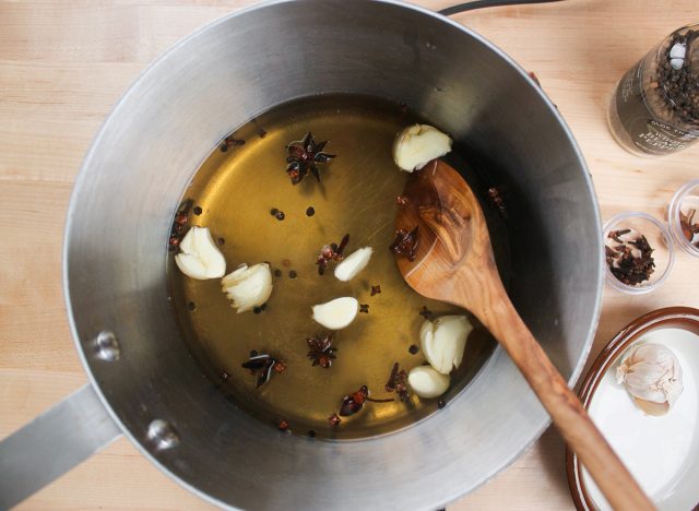 garlic cloves and spices cooking to make a brine for chicken