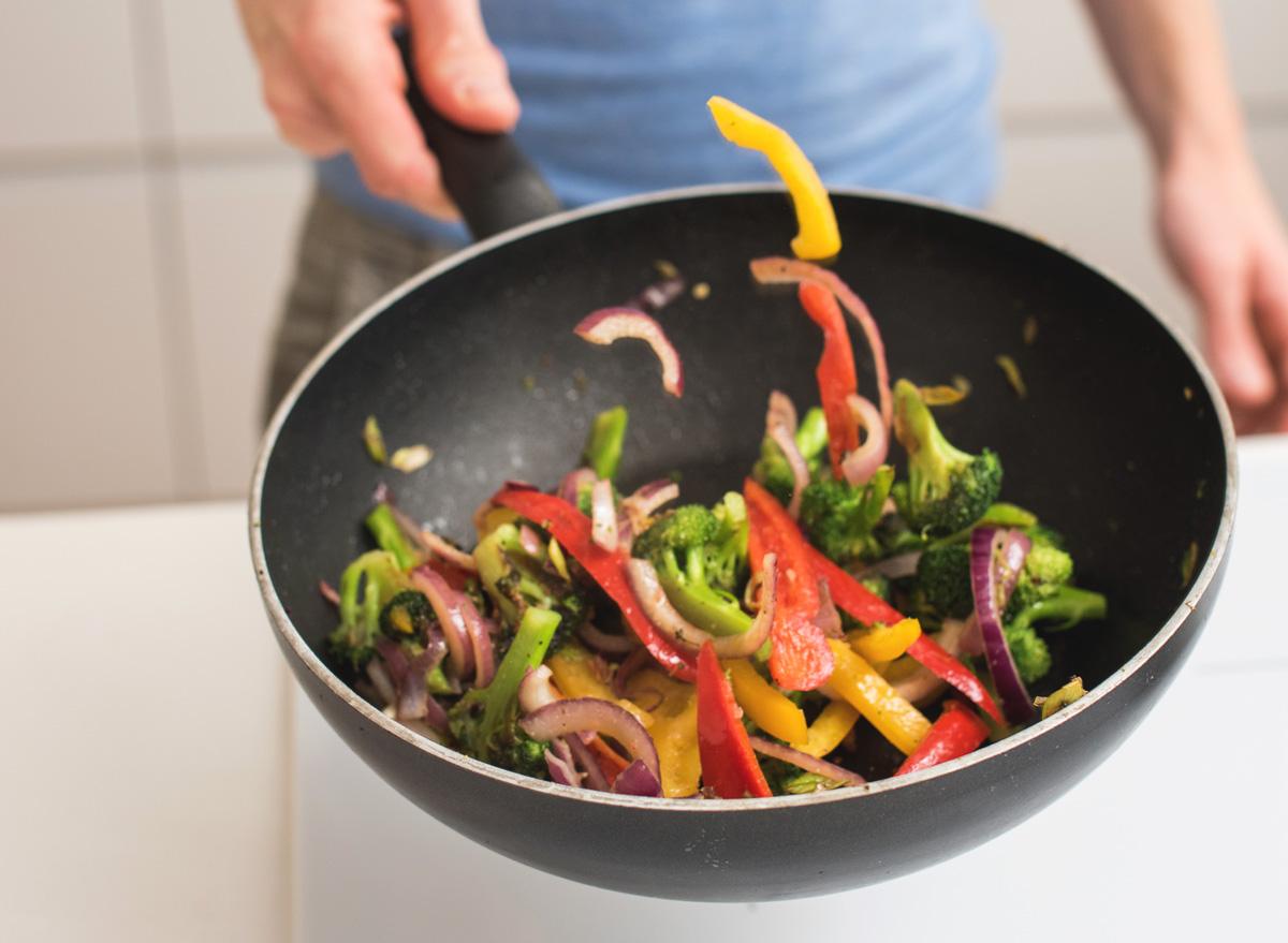 https://www.eatthis.com/wp-content/uploads/sites/4/2020/01/man-stir-fry-cooking-wok.jpg?quality=82&strip=1