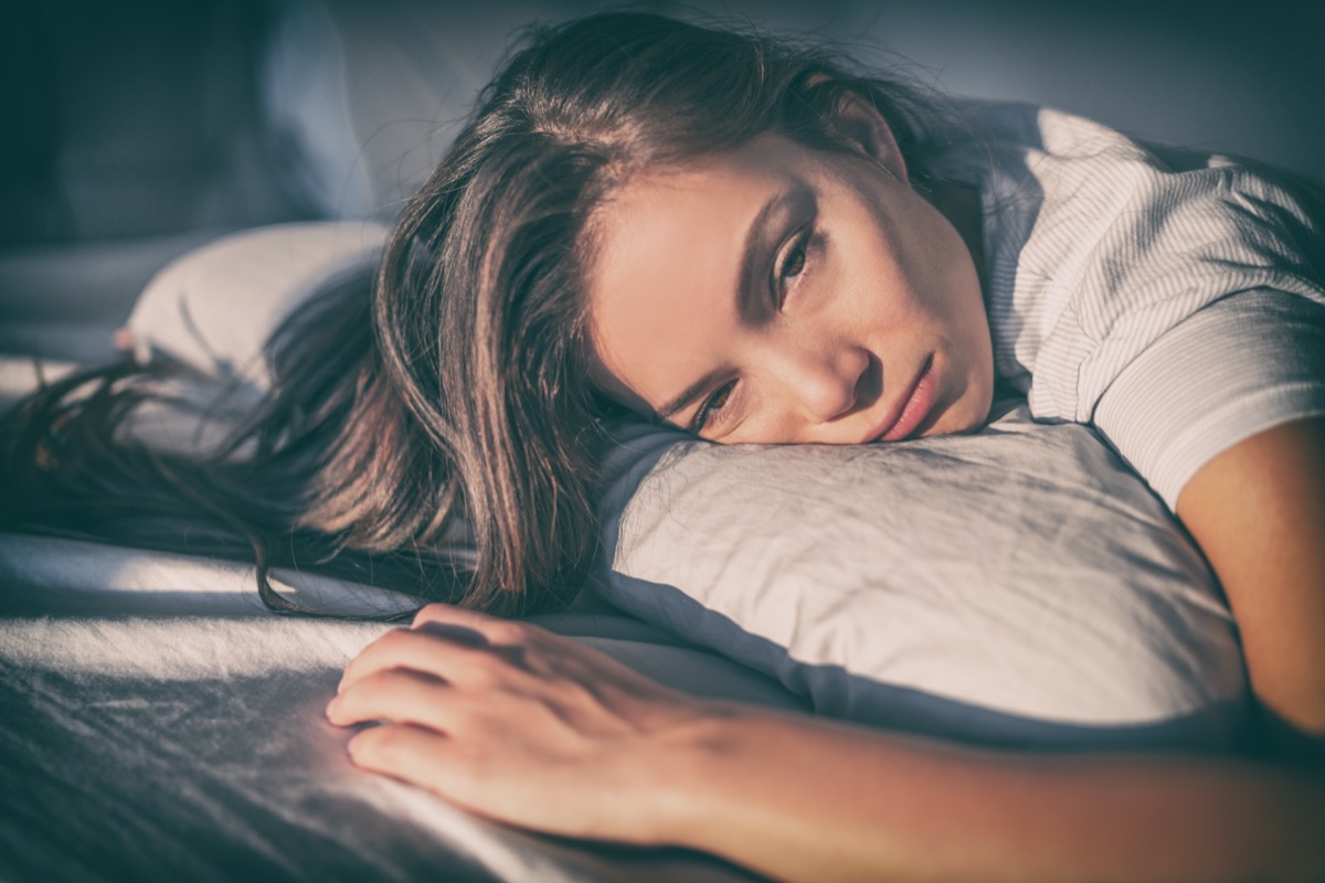 Tired woman lying in bed can not sleep late at night with insomnia