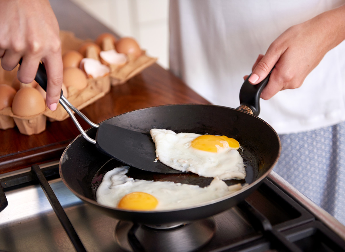 https://www.eatthis.com/wp-content/uploads/sites/4/2020/07/woman-frying-fried-egg-yolk-pan.jpg?quality=82&strip=1