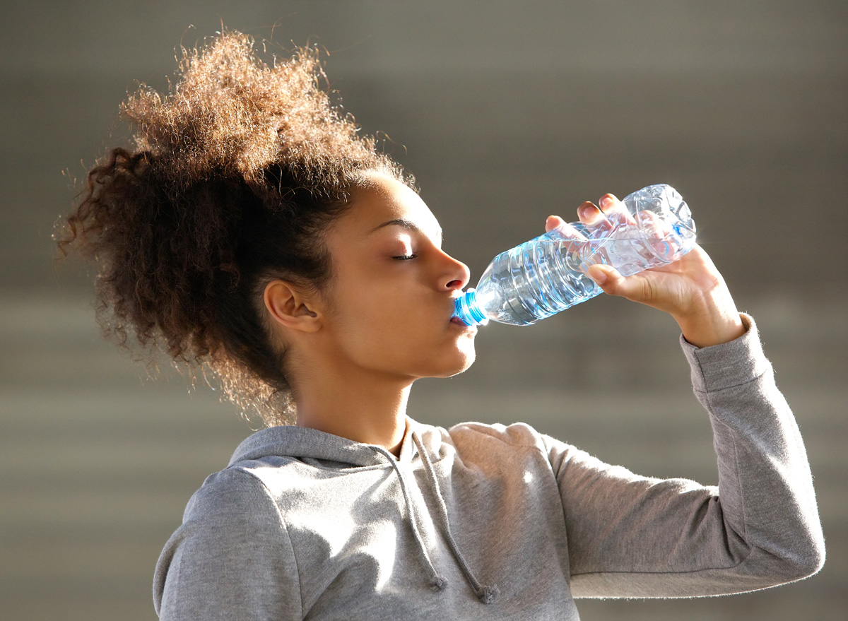https://www.eatthis.com/wp-content/uploads/sites/4/2020/08/black-woman-drinking-bottled-water.jpg?quality=82&strip=1