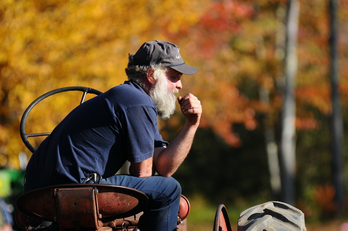 New Hampshire farmer sits on his tractor