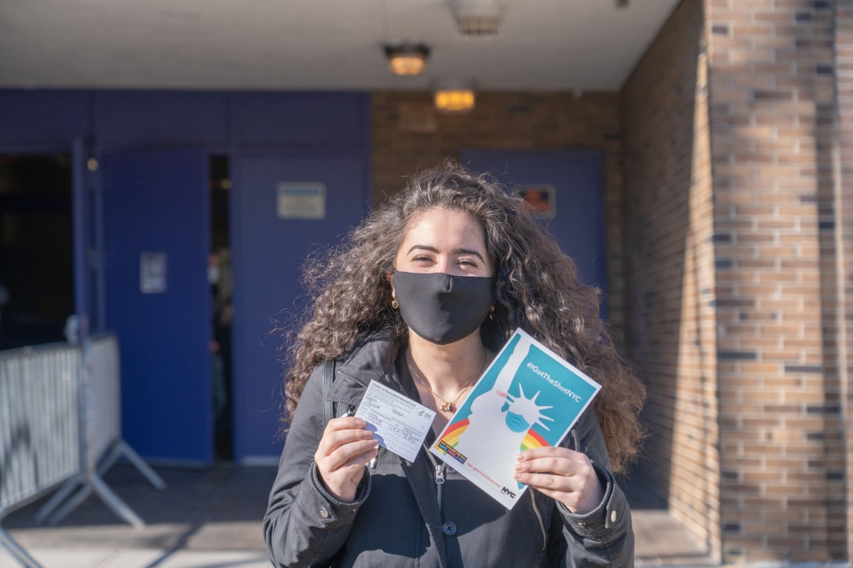 A woman displays her vaccination card and the 