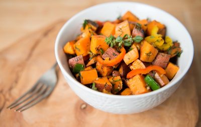 chopped sweet potato in white bowl next to fork