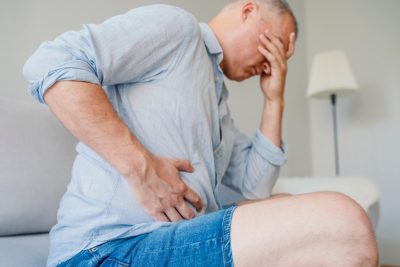 middle-aged man doubled over in liver pain