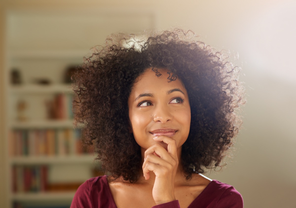 A thoughtful-looking young woman at home