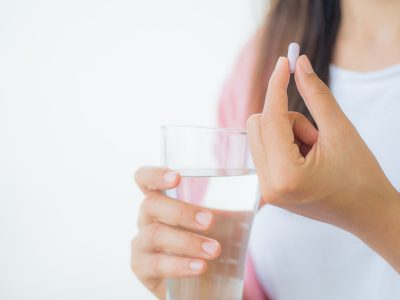 woman taking pill with water