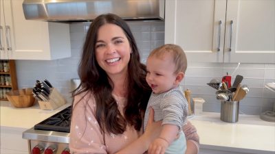 chef katie lee holding her baby daughter iris in a modern kitchen