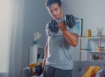 strong-man-lifting-dumbbells-living-room