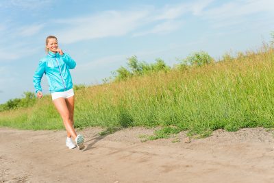 young woman running along a rural road, exercise outdoors