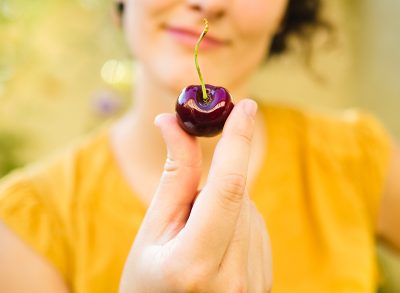 Beautiful young woman eating a cherry