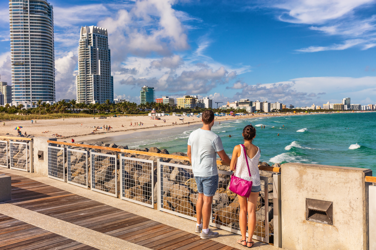 Miami beach tourists couple walking in South Beach, Miami, Florida.  USA travel.