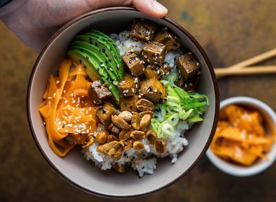 holding a vegan tofu sushi bowl