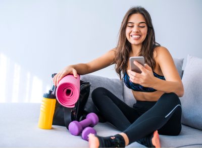 woman smiling while checking workout app