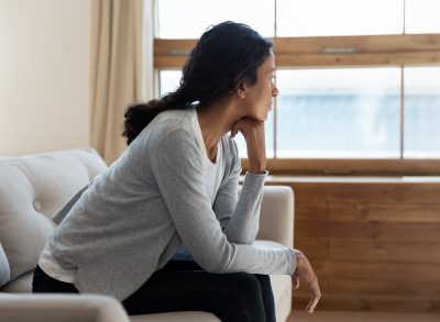 woman looking out the window experiencing cabin fever