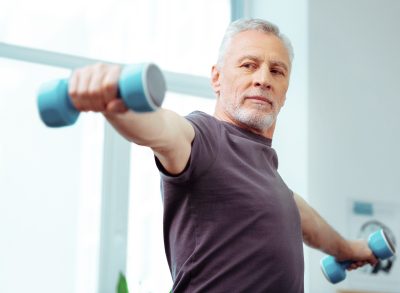 senior man raising dumbbells