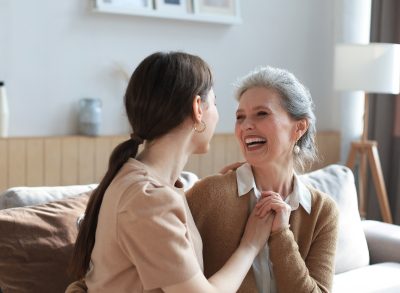 mother and daughter laugh on couch