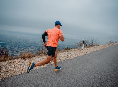 man running with city in background