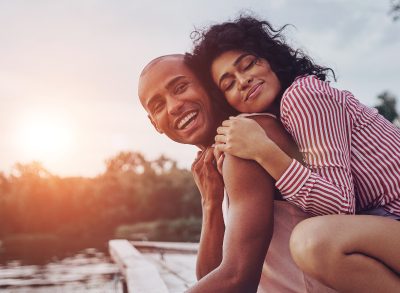 happy couple embraces at sunset on dock