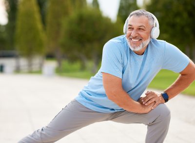 happy senior man stretches outside