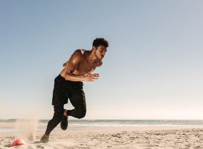 man sprinting at the beach