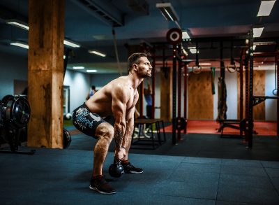 man performing intense kettlebell swings