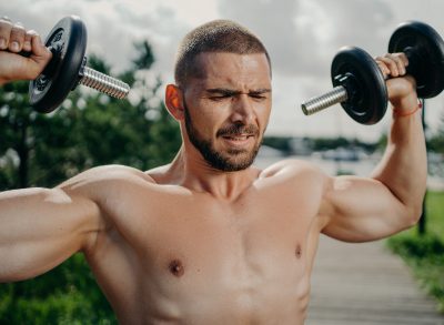 man lifting weights outdoors