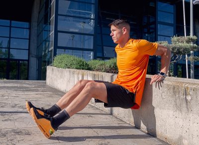 man doing tricep dips outside to tone sagging arm skin