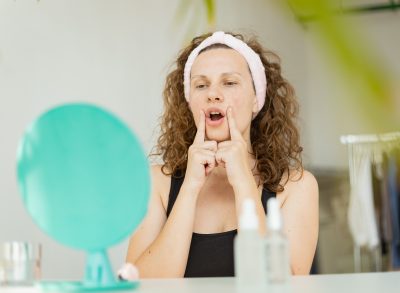 woman doing facial exercise to tone sagging skin under chin