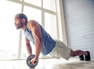 man doing ab wheel rollout