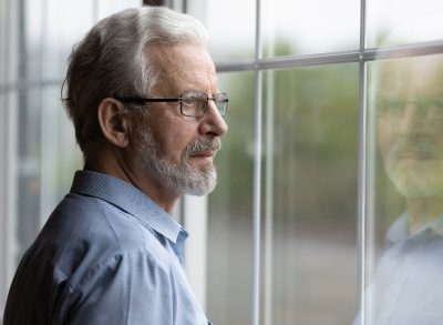 senior man looking out window