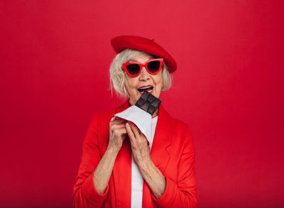 Stylish Elderly Woman Eats Chocolate