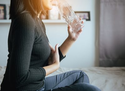 woman with acid reflux drinking water