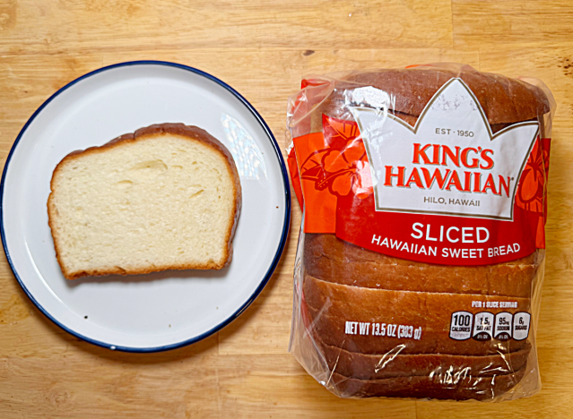 a loaf of kings hawaiin white bread with a slice next to a plate 
