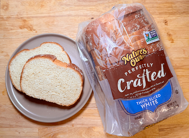 a loaf of natures own white bread with two slices on a plate 