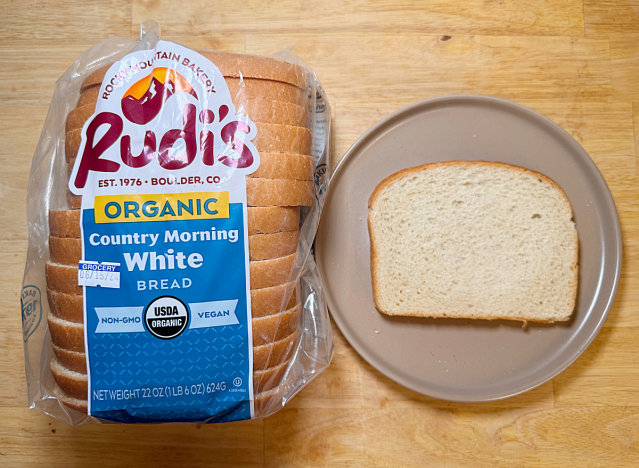 a loaf of rudi's bread with a slice on a plate 